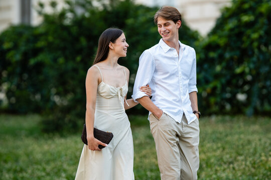 Young couple walking outdoors, smiling and happily interacting