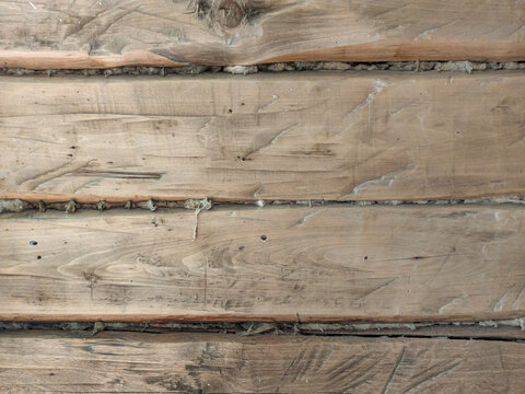 Horizontal wooden log wall texture background with natural timber grain and insulation seams