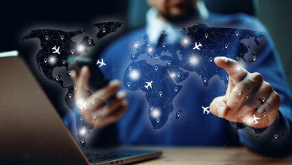 Man books travel using a laptop and smartphone with a map showing flight routes and locations © fotofabrika