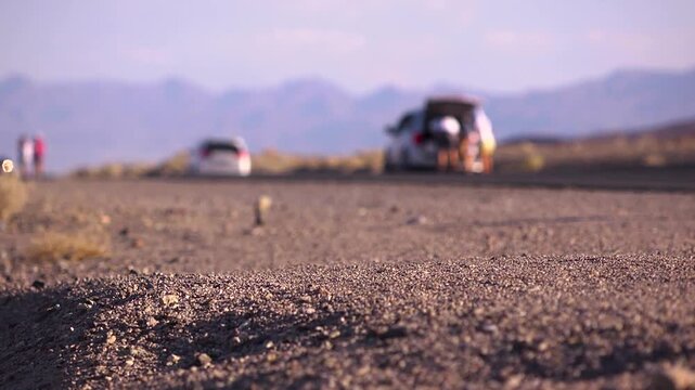 Close up of asphalt as marathon athletes run by in the desert