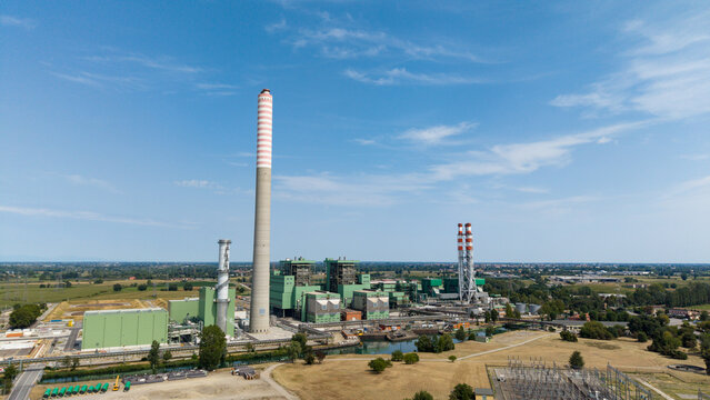 Aerial view of the TTEP Tavazzano thermal power plant and TERNA electrical substation with tall chimneys and industrial buildings in Tavazzano con Villavesco, Lombardy, Italy.