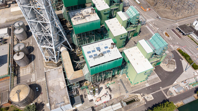 Aerial view of the TTEP Tavazzano thermal power plant and TERNA electrical substation with industrial buildings and cooling towers in Tavazzano con Villavesco, Lombardy, Italy.