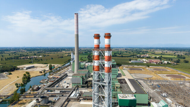 Aerial view of the TTEP Tavazzano thermal power plant and TERNA electrical substation with tall chimneys and industrial facilities in Tavazzano con Villavesco, Lombardy, Italy.