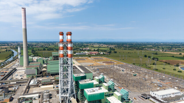Aerial view of the TTEP Tavazzano thermal power plant and TERNA electrical substation with tall chimneys and industrial infrastructure in Tavazzano con Villavesco, Lombardy, Italy.
