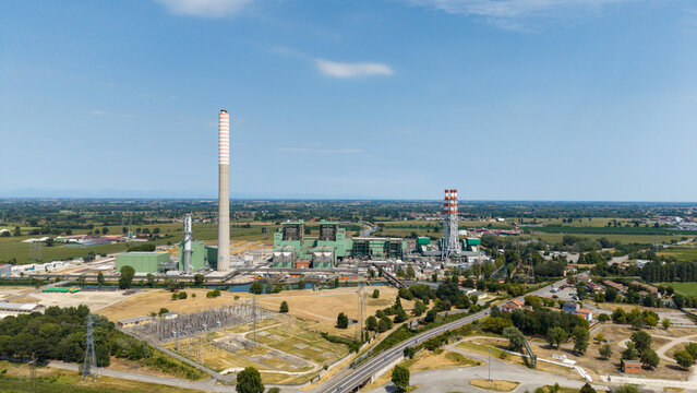 Aerial view of the TTEP Tavazzano thermal power plant and TERNA electrical substation, featuring industrial chimneys and cooling towers in Tavazzano con Villavesco, Lombardy, Italy.