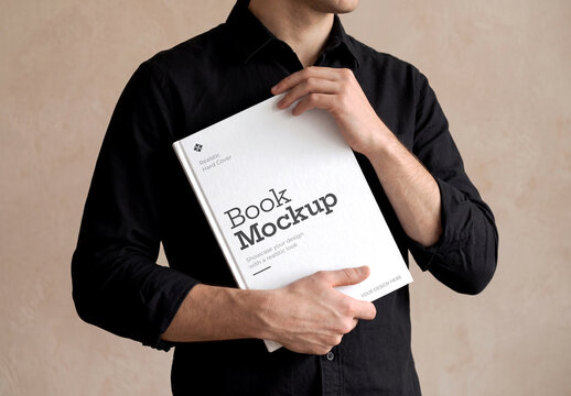 Man Holding Hardcover Book Mockup Vertically Under Arm Side View on Beige Background