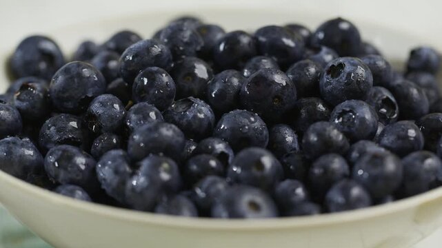 Bowl filled with fresh blueberries - closeup tracking shot