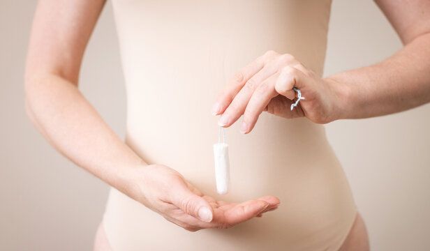 A woman holds choice of sanitary tampons, feminine hygiene product.