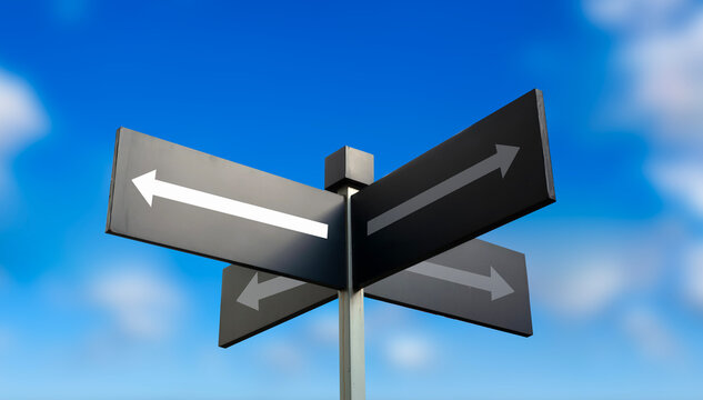 Black directional arrow signpost against vibrant blue sky clouds