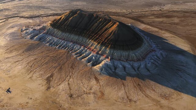 Aerial view of the unique striped sedimentary layers of Mount Bokty in the desert landscape of the Karakiya District, Mangystau Region, Kazakhstan.