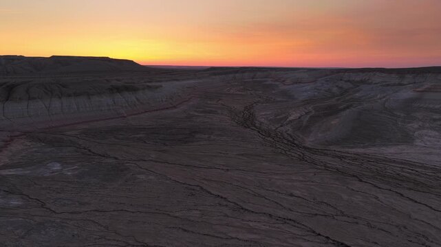 Aerial view of the arid landscape and Mount Bokty during golden hour in Karakiya District, Mangystau Region, Kazakhstan.