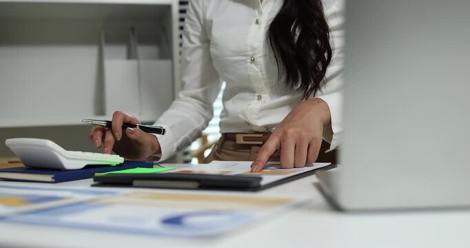 Business professional reviewing financial reports, analyzing business performance, calculating budgets and managing office documents with digital devices for accounting, finance and corporate planning