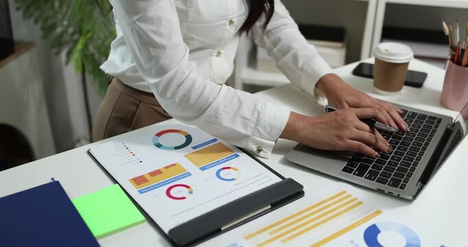 Business professional reviewing financial reports, analyzing business performance, calculating budgets and managing office documents with digital devices for accounting, finance and corporate planning