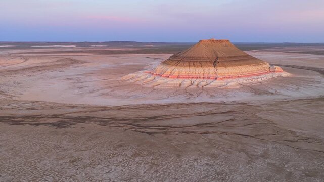 Aerial view of Mount Bokty, a unique striped mountain rising from the arid desert landscape in Karakiya District, Mangystau Region, Kazakhstan.