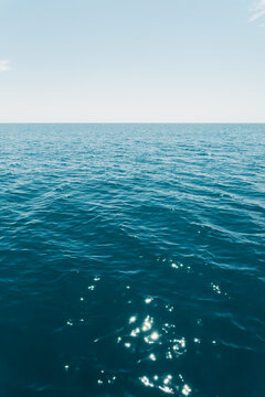 Blue sea water background texture with Gentle Water Movement. Blue ocean water surface with gentle waves, natural ripples, and soft sunlight reflections