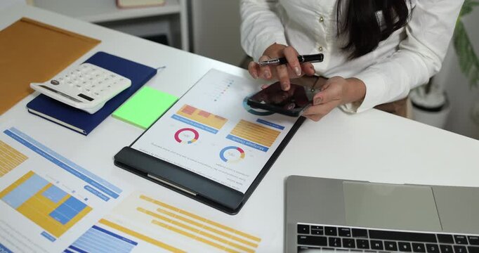 Business professional reviewing financial reports, analyzing business performance, calculating budgets and managing office documents with digital devices for accounting, finance and corporate planning