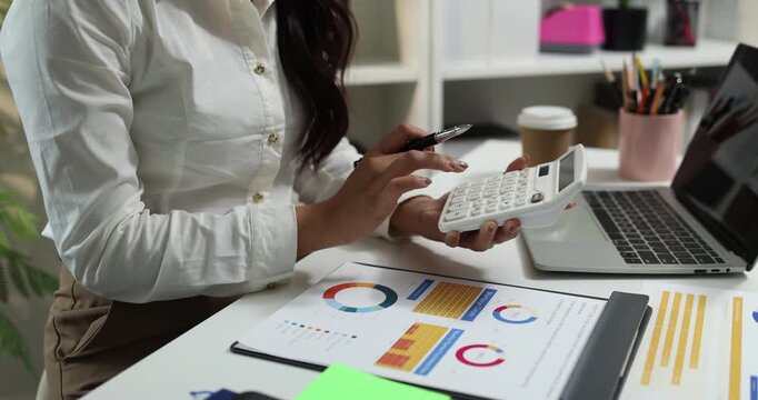 Business professional reviewing financial reports, analyzing business performance, calculating budgets and managing office documents with digital devices for accounting, finance and corporate planning