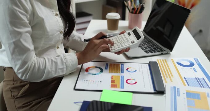 Business professional reviewing financial reports, analyzing business performance, calculating budgets and managing office documents with digital devices for accounting, finance and corporate planning