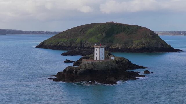 Aerial view of Phare de L'Ost-Pic lighthouse on a rocky islet surrounded by the sea in Plouezec, France.
