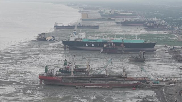 Aerial view of large cargo ships and tankers beached on the mudflats at the Ship Breakers Yard in Bhatiari, Chittagong Division, Bangladesh.