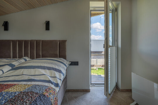 Bedroom Interior with Bed and Open Balcony Door