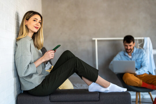 Smiling woman enjoys digital chatting, mobile communication at home, staying connected with friends