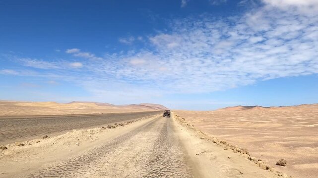 Buggy driving on remote desert dirt road in Paracas Peru