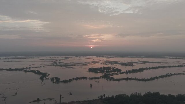 Aerial view of the flooded Gumai Beel wetlands during a golden sunset in Rangunia Upazila, Chittagong Division, Bangladesh.