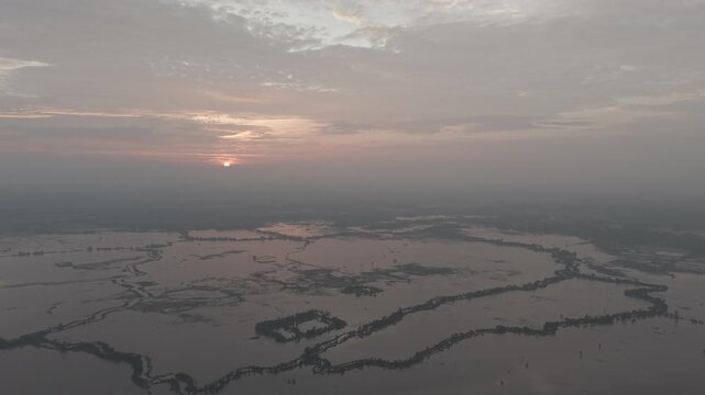 Aerial view of the flooded Gumai Beel landscape during sunset with calm waters reflecting the sky in Rangunia Upazila, Chittagong Division, Bangladesh.