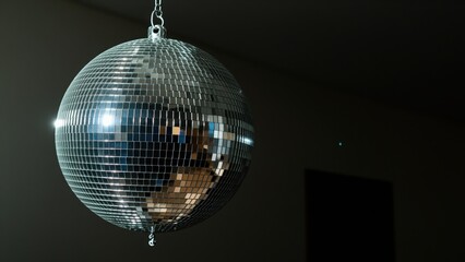 Obraz premium Disco Ball Brilliance: A sparkling disco ball hangs suspended, its mirrored facets reflecting light and creating a dazzling spectacle, hinting at a night of music and celebration.