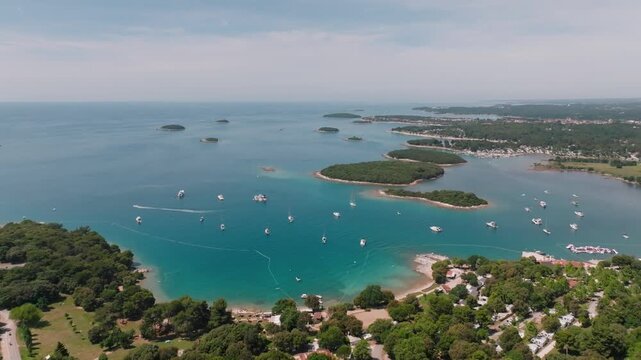 Aerial view of the Vrsar coastline with numerous small islands, turquoise waters, and anchored boats along the Adriatic Sea in Vrsar, Istria County, Croatia.