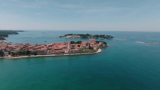 Aerial view of the historic old town of Porec with its red-tiled rooftops and the Euphrasian Basilica tower overlooking the Adriatic Sea in Porec, Istria County, Croatia.