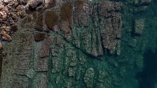 Aerial view of rocky coastline with clear turquoise water along the Mediterranean sea in Moraira, Valencian Community, Spain.