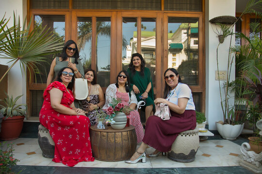 Portrait of a women sitting together in the backyard during a get together. 