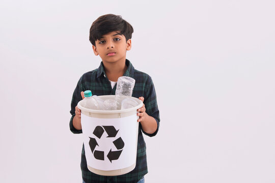 Young boy holding a recycling bin with plastic bottles. (Children) 