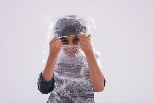 Young boy trying to look through the plastic wrapped around his face. (Children) 