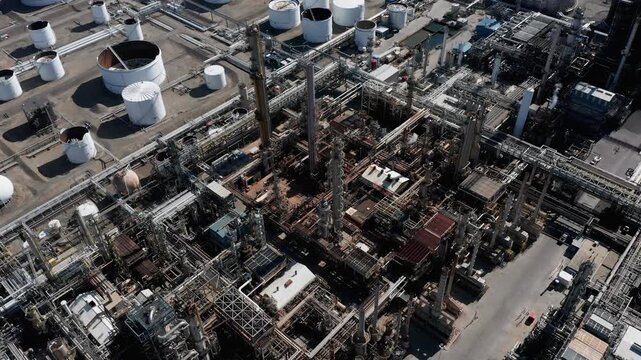 Aerial view of oil refinery featuring complex piping systems, tall distillation columns, and numerous storage tanks in Billings, Montana, United States.