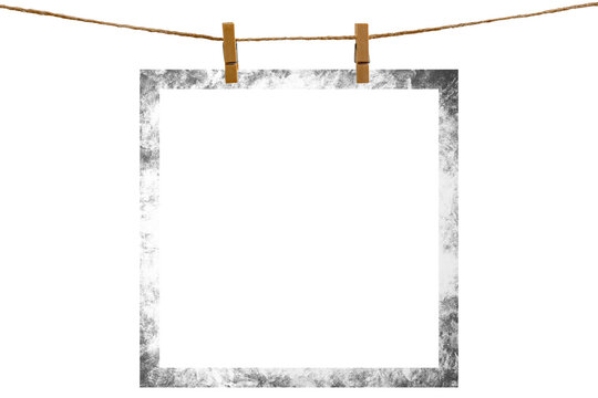 Blank photo frame hanging on a rope with a wooden clothespin. Isolated transparent PNG mockup.
