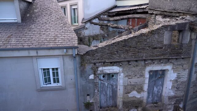 Casa antigua y destruida en el casco hist&oacute;rico de Lugo, con fachada deteriorada, ventanas rotas y signos visibles de abandono y paso del tiempo.
