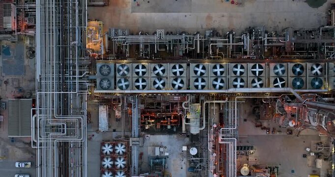 Aerial view of the industrial infrastructure and cooling fans at the Joliet oil refinery, featuring complex piping networks and metallic structures in Joliet, Illinois, United States.