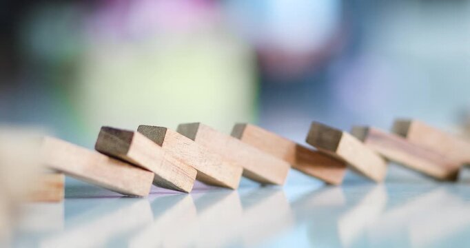 Wooden dominoes falling in sequence, chain reaction, risk, business strategy, decision making, failure, change, crisis, leadership, and cause-and-effect concepts