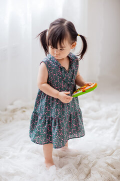 Cute Asian little girl playing indoors