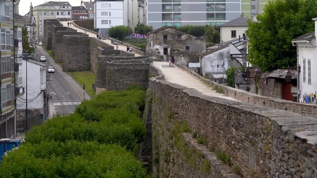 Vista general desde lo alto de un tramo recto de la muralla romana de Lugo, mostrando el paseo de ronda y la estructura defensiva de piedra.