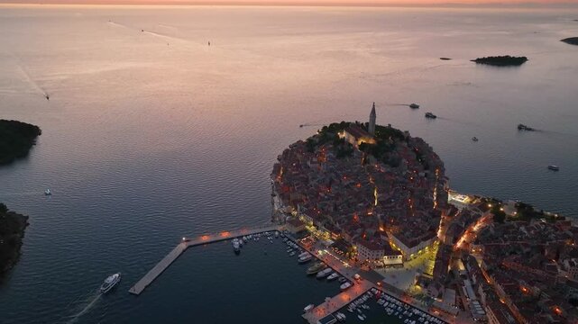 Aerial view of the historic old town of Rovinj situated on a peninsula surrounded by the Adriatic Sea during a golden sunset in Rovinj, Istria County, Croatia.