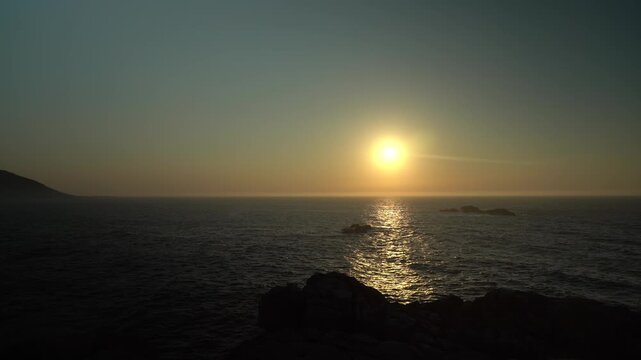 Paneo horizontal de la inmensidad del oc&eacute;ano Atl&aacute;ntico al atardecer, con el sol de frente reflej&aacute;ndose sobre el horizonte y las aguas del mar.