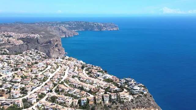 Aerial view of the coastal town of Moraira with white villas nestled on cliffs overlooking the Mediterranean Sea in Moraira, Valencian Community, Spain.
