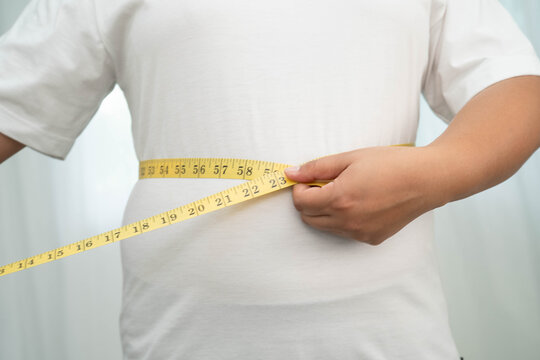 Asian woman with fat belly big size overweight and obesity with measure tape.