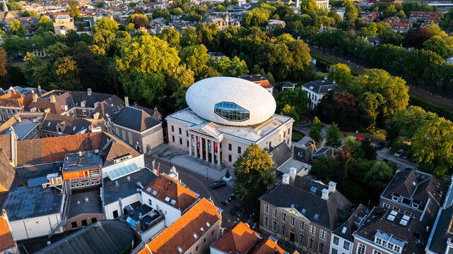 Aerial view of Museum de Fundatie with its iconic white oval roof structure surrounded by historic buildings and lush urban greenery in Zwolle, Overijssel, Netherlands.
