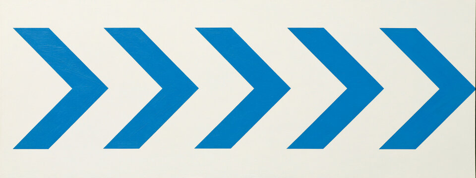 Blue chevron arrows pointing right. Directional signs indicating forward movement.
