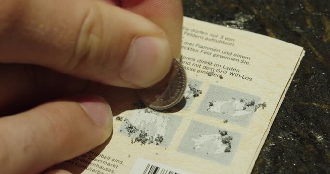 Close-up of a person scratching a lottery scratch card with a coin, revealing a losing result and illustrating luck, gambling, and chance.